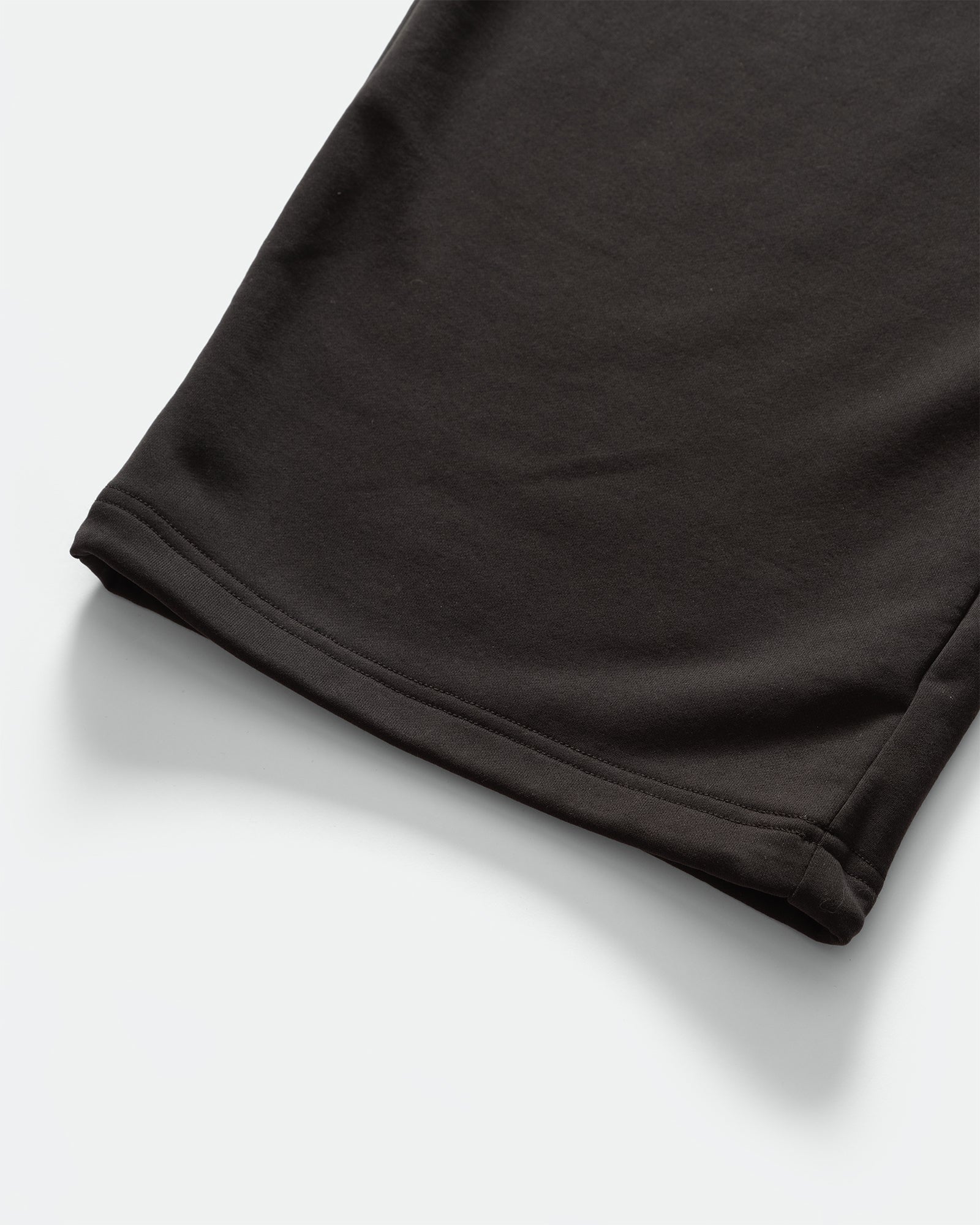 Close up of the cuffs of KANAMASA PHIL Black Cupro Easy Pants on a grey background.