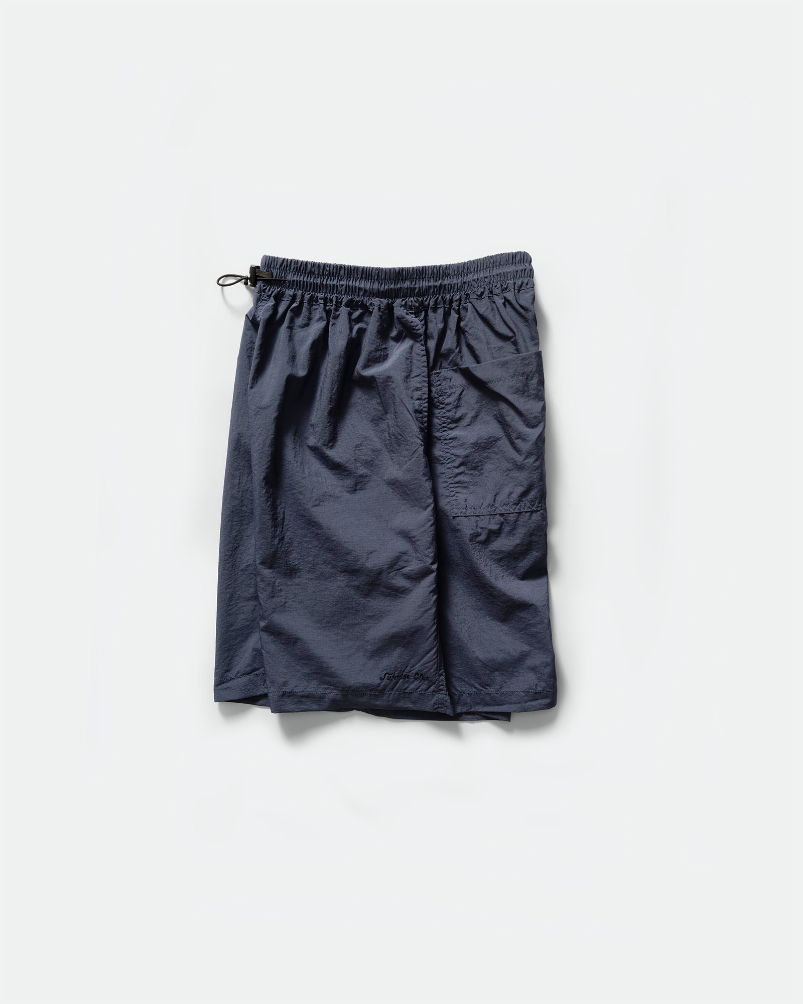 Side pack shot of Kappy navy nylon shorts with an elasticated drawstring waistband on a grey background 