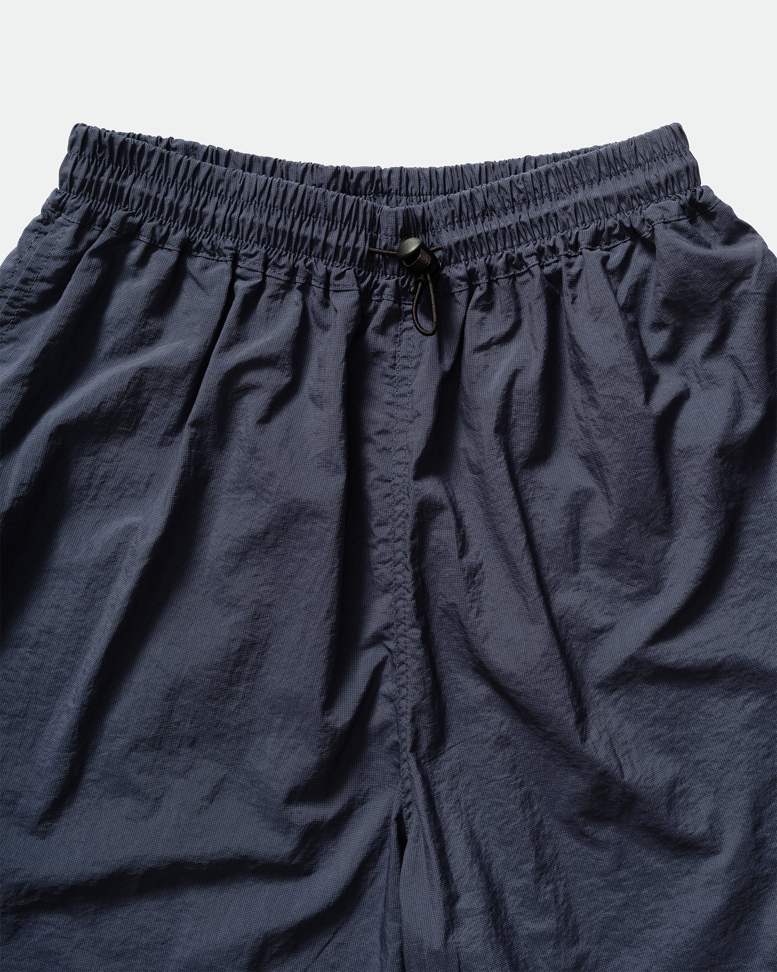 Close-up of nvy Kappy nuylon shorts with a drawstring elasticated waistband on a light background