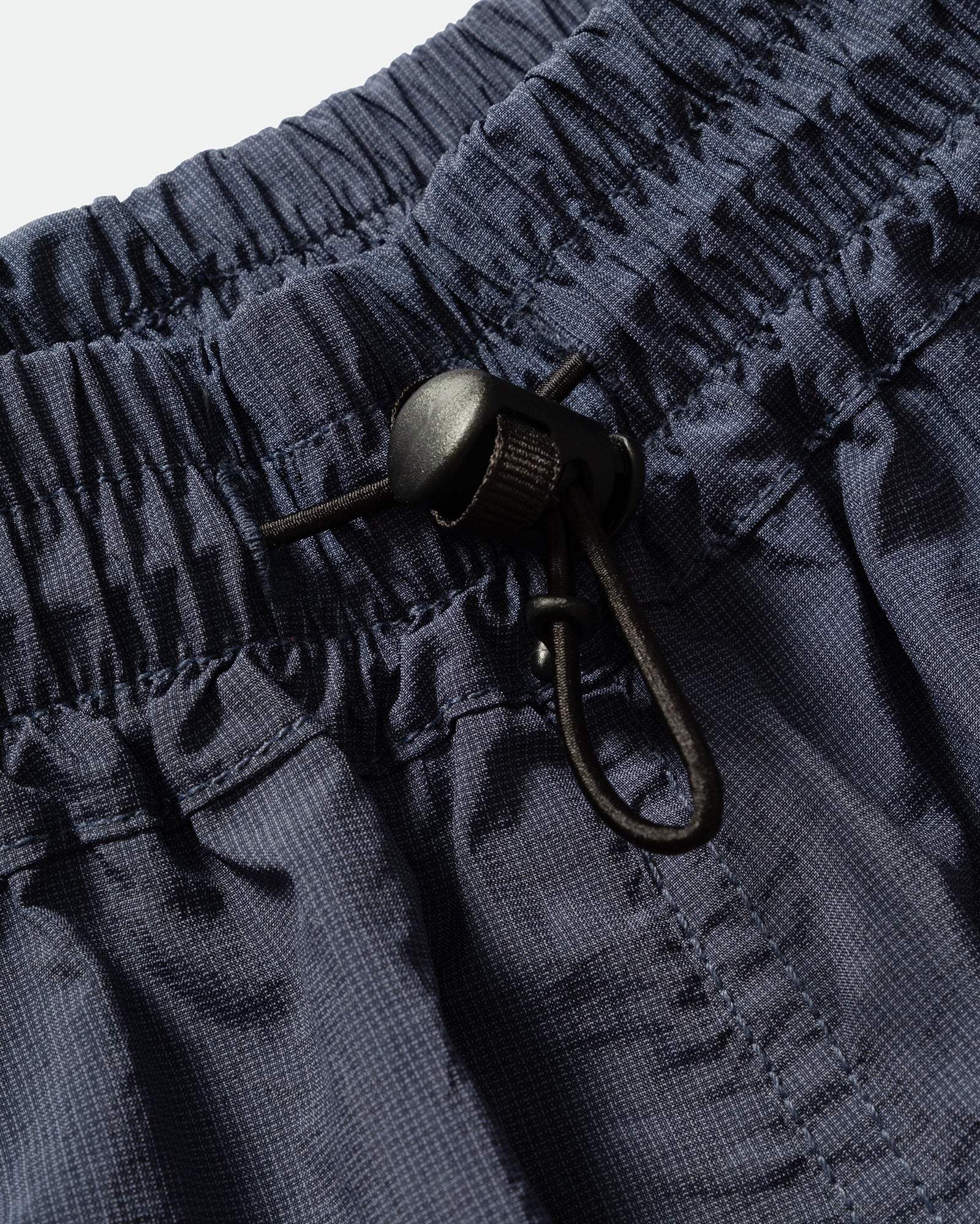 Close-up of brown kappy nylon shorts with a black drawstring and elasticated waistband.