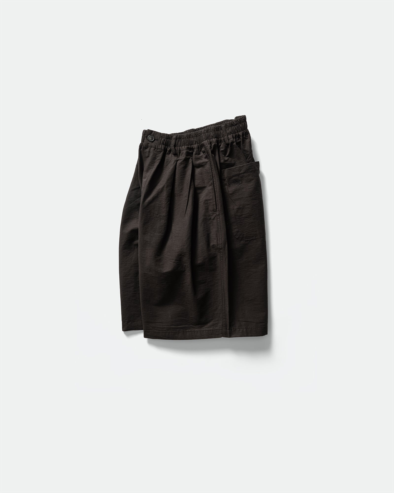 Pack shot of black Kappy shorts to the side with back pocket and elasticated waistband on a grey background