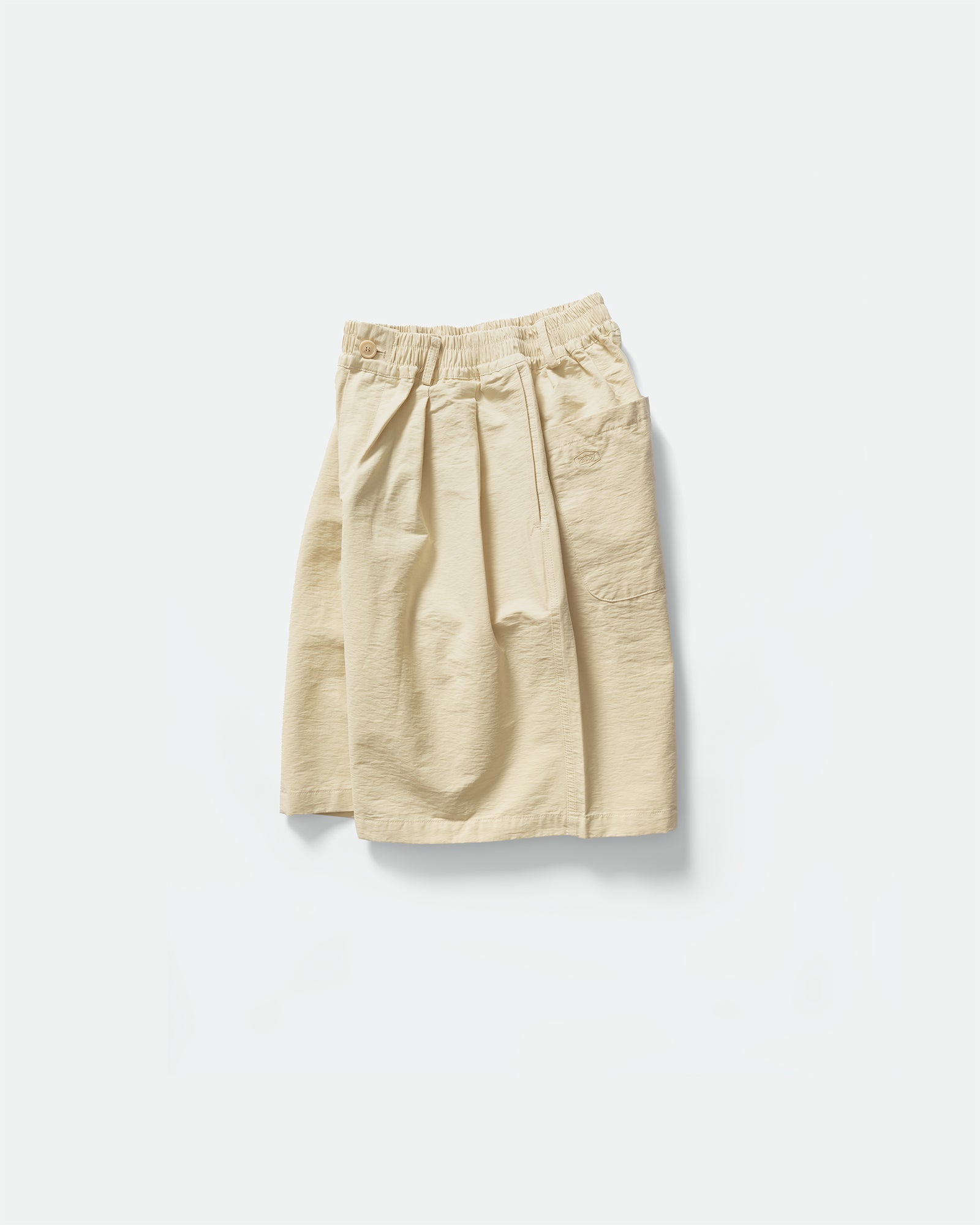 Pack shot of cream Kappy shorts to the side with back pocket and elasticated waistband on a grey background