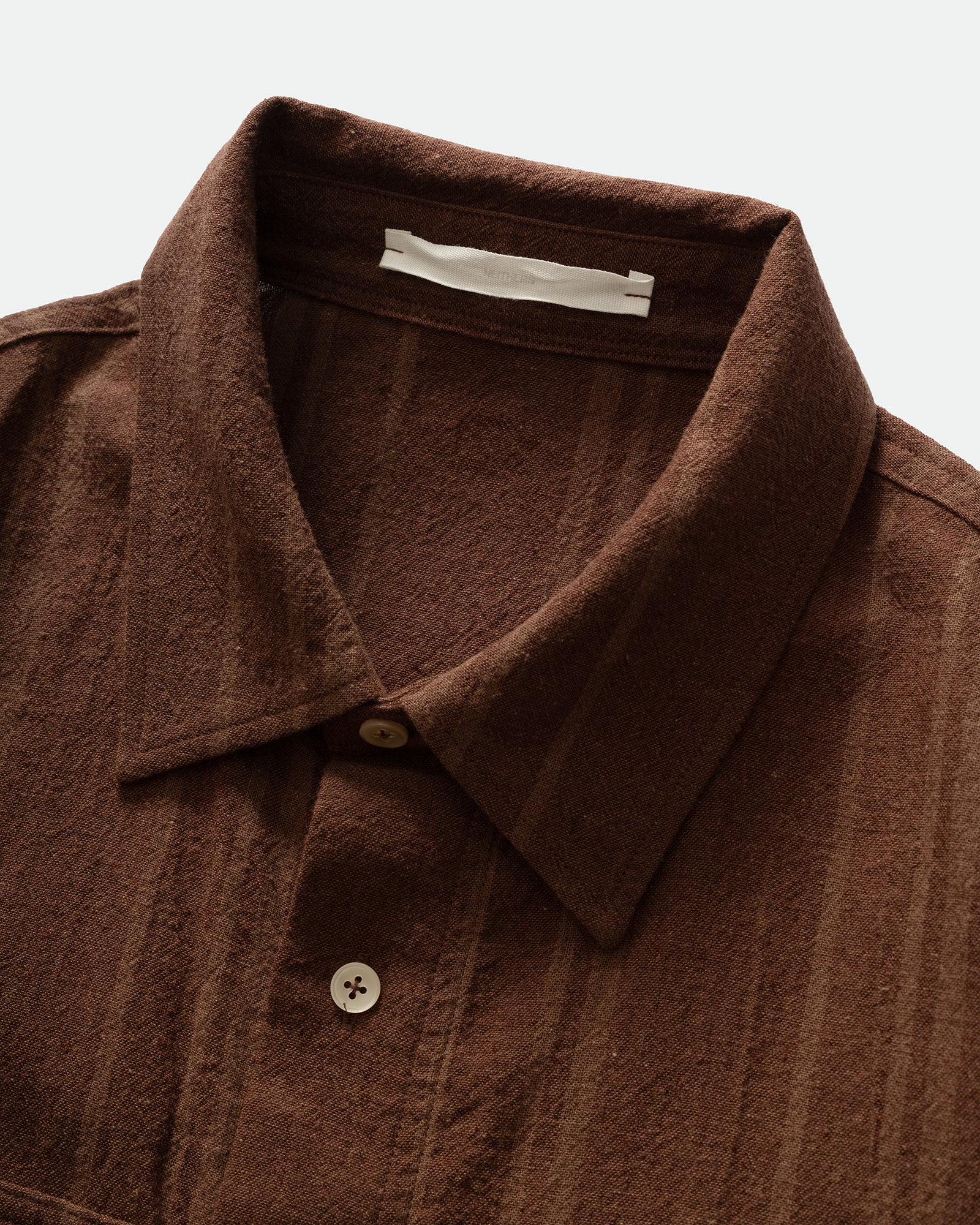 Brown shirt with collar and buttons on a light gray background