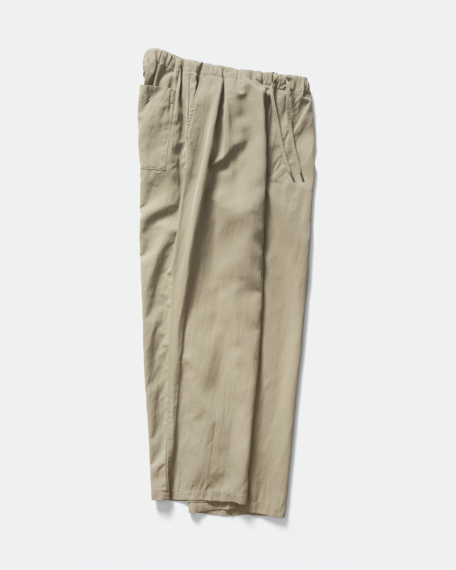 Side pack shot of Still By Hand Sage Pigment Print Easy Pants with a drawstring waistband and slip pockets on a grey background.